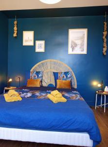 a blue bedroom with a large bed with blue walls at La Cabane des Mouts- Piscine -Clim in Fleury +28 photos