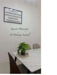 a dining room table with a plant on it at Iman4 Homestay in Kampung Behrang