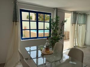 a dining room with a glass table and a window at Villa LiLo Private House with Heated Pool in Costa Teguise