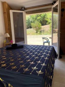 a bedroom with a bed with a blue and gold bedspread at Chambre d'Hôtes Chez Tania et Benoit in Borgo +7 photos