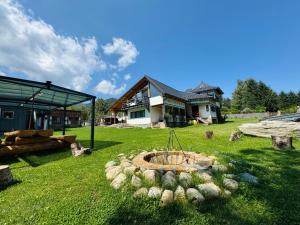 un patio con una hoguera frente a una casa en Vila Eruga- Apartament 2, en Poiana Mărului
