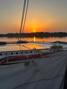a boat on the water with the sunset in the background at Assuan Felucca in Aswan