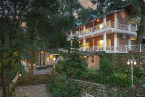a large house in the woods at night at Echor Malusara Lakeview Retreat Bhimtal in Bhīm Tāl