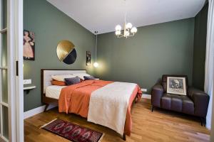 a bedroom with a bed and a chair at Central oLiv Apartment with free parking in Timişoara