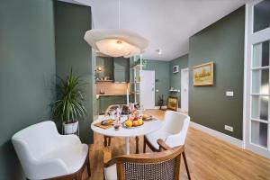 a dining room with a table and white chairs at Central oLiv Apartment with free parking in Timişoara