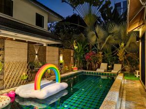 a swimming pool with a rainbow in the middle at Thonglor 25 Noble House in Bangkok