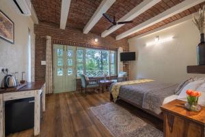 a bedroom with a bed and a desk with a television at Echor Malusara Lakeview Retreat Bhimtal in Bhīm Tāl