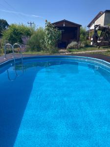 a large blue swimming pool in front of a house at Roubenka Koněšín in Koněšín