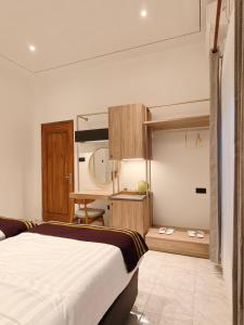 a bedroom with a bed and a desk at Tentram guesthouse in Waikabubak
