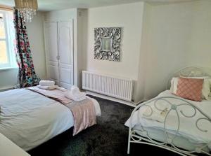 a bedroom with two beds and a mirror on the wall at Chantry Place Morpeth House in Morpeth