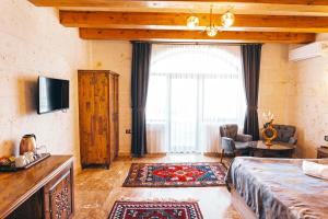 a bedroom with a bed and a large window at Nest Cappadocia Hotel in Uçhisar
