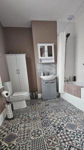 a bathroom with a sink and a toilet and a tub at SNUZE Whitby 2 in Whitby