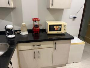 un comptoir de cuisine avec un four micro-ondes. dans l'établissement Prestige comforts, à Karachi