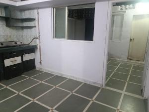 a bathroom with a white door and a tiled floor at Home Stay - Maa Kaamal Deep in Surat