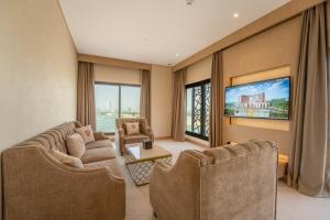 a living room with two couches and a tv at World Heart Hotel in Baghdad