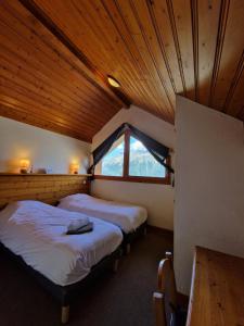 two beds in a room with a large window at Chalet Beyond - Gelinotte in Oz