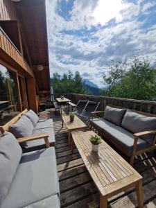 a patio with couches and tables on a deck at Chalet Beyond - Gelinotte in Oz