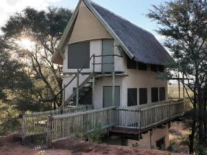 una casa antigua con techo de paja y porche en Kazondwe Camp and Lodge, en Kongola