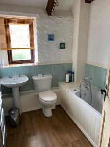 un bagno con un water, una vasca e un lavandino di Riscombe Farm Cottages a Exford Altre 51 foto