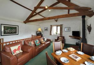 un soggiorno con un divano e un tavolo di Riscombe Farm Cottages a Exford