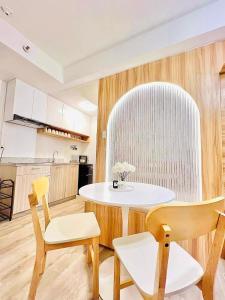 a kitchen with a table and chairs in a room at Reflective Woodscape- 1 Bedroom with Balcony in Bacolod