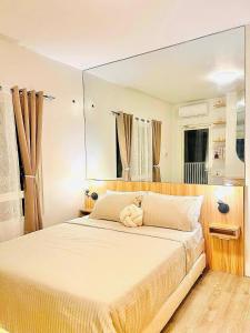 a teddy bear sitting on a bed in a bedroom at Reflective Woodscape- 1 Bedroom with Balcony in Bacolod +21 photos
