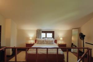 a bedroom with a bed with two lamps and a window at Casa da Alvarinha Privacidade, Conforto, Natureza in Paredes