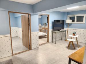 a room with blue walls and a door and a television at Mook Seoul in Seoul