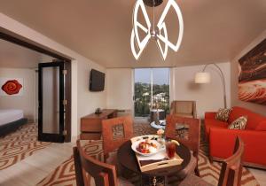 a living room with a red couch and a table at Hotel Angeleno in Los Angeles
