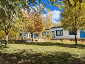 a white house with trees in front of it at Lharimo North Cottages - Nubra Valley in Wāhegaon