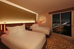 a hotel room with two beds and a large window at Hotel Angeleno in Los Angeles