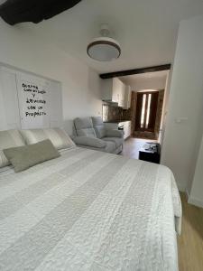 a bedroom with a large white bed and a couch at CASA CRISTINA Alojamiento céntrico en pleno casco histórico y centro de la ciudad in Monforte de Lemos