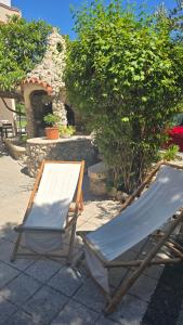 two lounge chairs and a table on a patio at Apartments Ribica in Rab