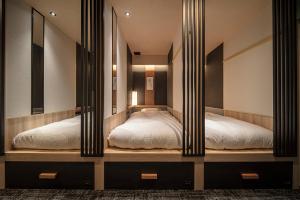 two beds in a room with mirrors at ENSO TOKYO Akasaka in Tokyo