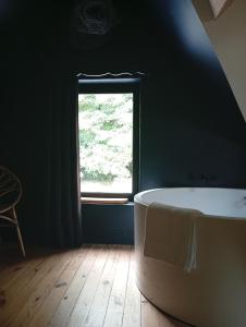 a bath tub in a room with a window at Cottage Montreuil-sur-mer Petit déjeuner inclus in Écuires