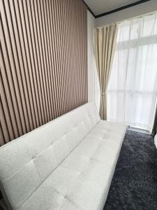 a white couch in a room with a window at 若葉コーポ103 in Fukuoka