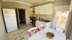 a kitchen with a table and a white refrigerator at Peribacası Manzaralı Modern Daire 2 in Urgup