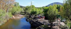 a group of people standing next to a river at Alojamientos El Chorro in Los Navalucillos