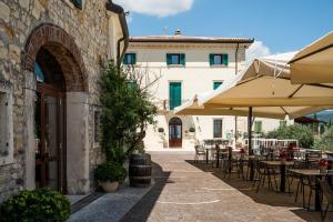 a patio with tables and umbrellas in front of a building at Castrum Wine Relais - Albergo Diffuso in San Pietro in Cariano