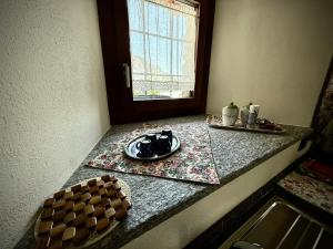 a kitchen counter with a plate of food and a window at La maison du faux monneyeur in Saint-Rhémy-en-bosses +11 photos