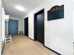 a hallway with black doors and a chalkboard on a wall at bonquartier - Design Apartment mit Balkon, Arbeitsplatz und Parkplatz in Wachtberg