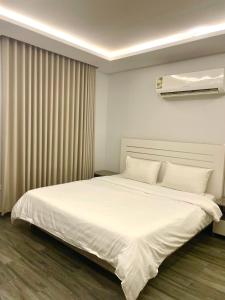 Un dormitorio con una cama grande con sábanas blancas. en شقة 9, en Al-Safa