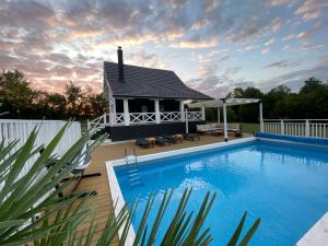 a swimming pool with a gazebo and a house at Moje srećno mesto in Arandelovac