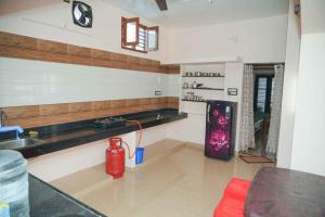 a kitchen with a sink and a red fire hydrant at KHS Lakshmi-G in Ambāsamudram