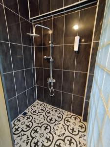 a bathroom with a shower with black and white tile at Gölyaka Hotel in Bursa