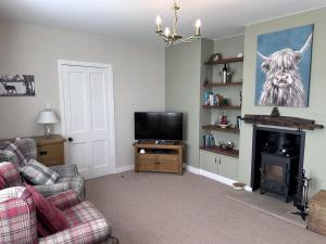 a living room with a couch and a television at Bon Accord in Fort Augustus