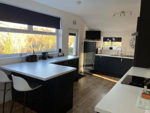 a kitchen with black cabinets and a large window at Bon Accord in Fort Augustus