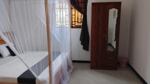 a bedroom with a bed and a staircase with a mirror at Maku House in Makunduchi