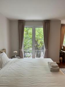 a bedroom with a large white bed and a window at Entire 3BR Townhome in Sukhumvit, shared Pool, near BTS&MRT Asok in Bangkok +72 photos