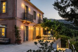 a house with a patio and a table in front of it at Villa Daphni in Ayia Evfimia